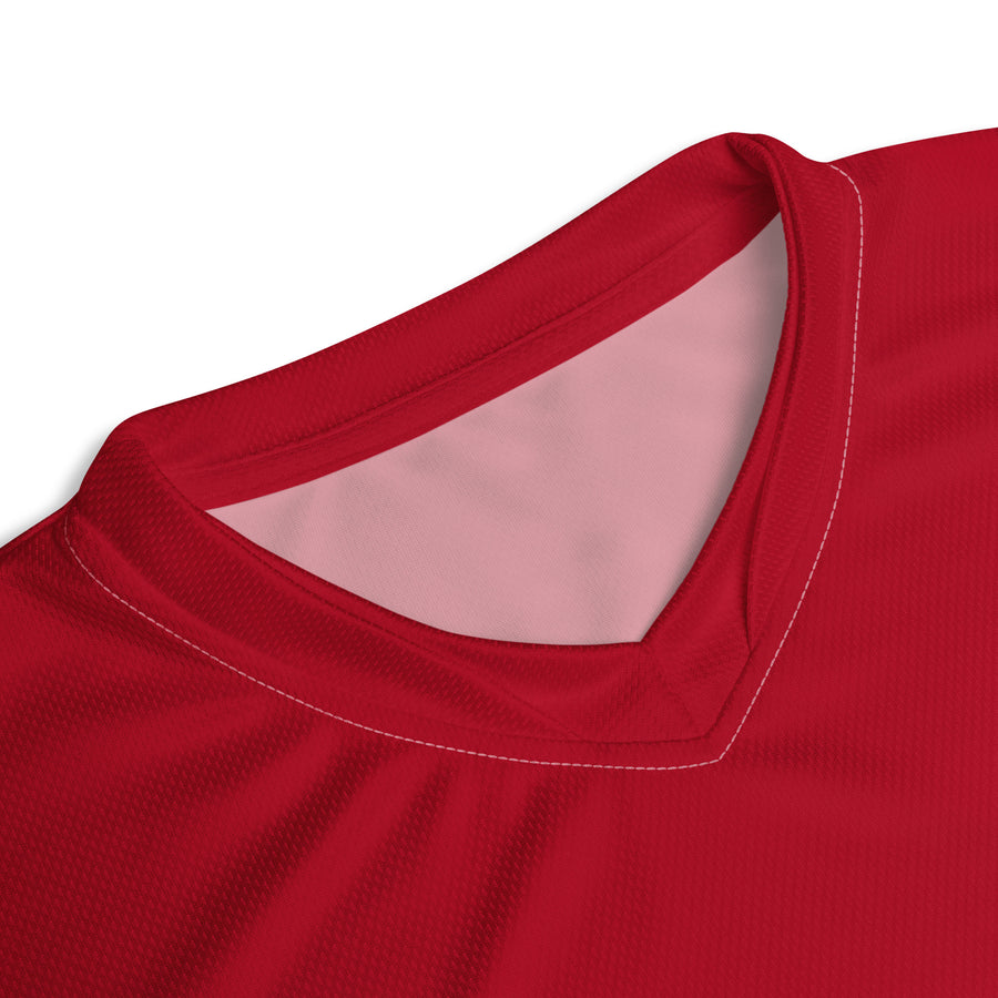 Close-up of the V-neck collar of the England cricket jersey, highlighting the neat stitching and contrast between the red and inner pink fabric.