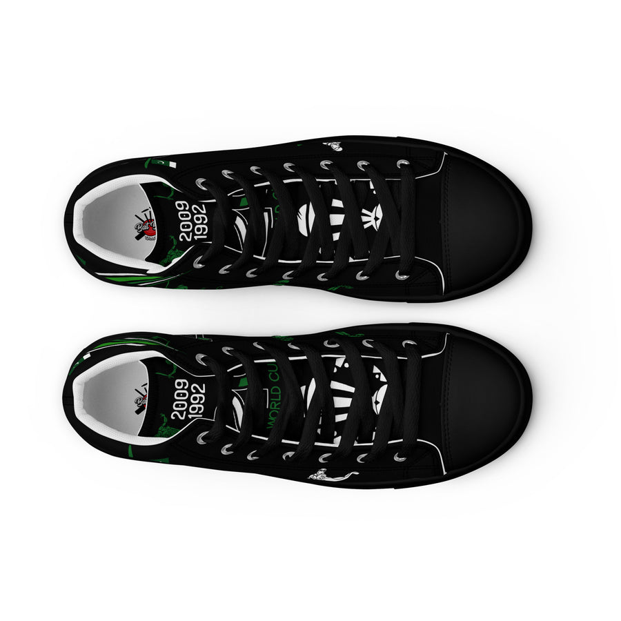 Top view of a pair of black high-top canvas shoes with green accents and white laces, showcasing the words '2009 WORLD CUP' and '1992 WORLD CUP' printed on the insole, along with a white cricket graphic design.