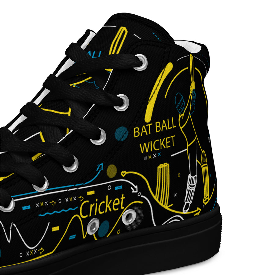 Side view of men's high-top canvas shoes displaying a dynamic yellow outline of a cricket batsman, along with equipment and terms like "bat," "ball," and "wicket" in stylized fonts on a black background.