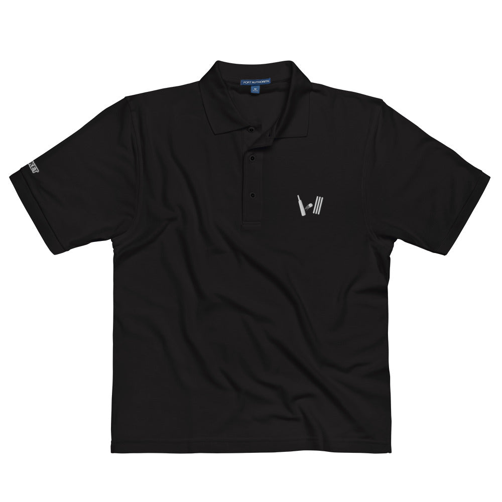 Front view of a black polo shirt laid flat, featuring a cricket bat and stumps embroidery on the chest, designed for fans and casual wear.