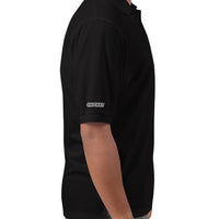 Side view of a man wearing a black polo shirt, showing the 'CRICKET' logo embroidered on the right sleeve, ideal for sports enthusiasts.