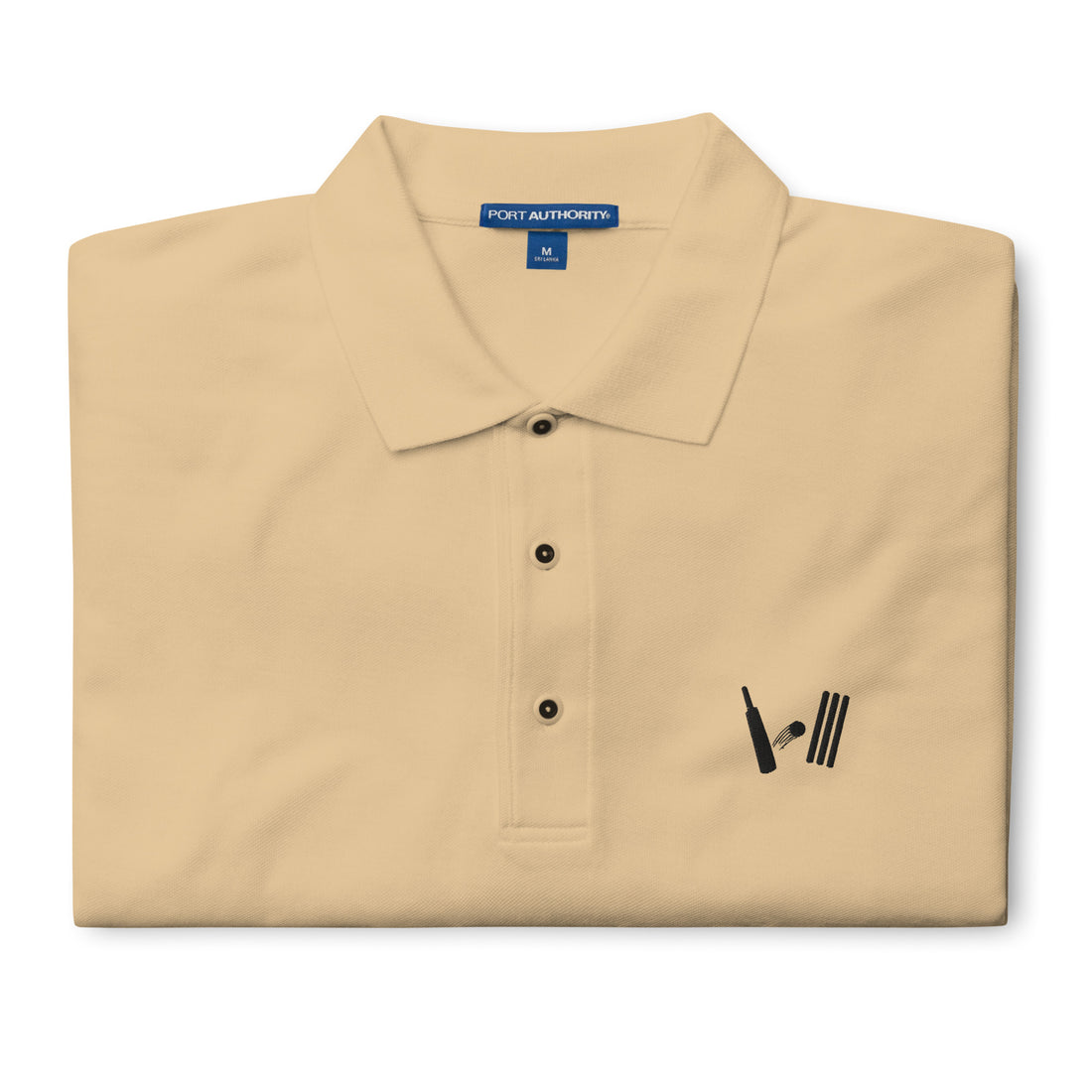 Folded beige Port Authority polo shirt with Bat Ball Wicket logo detail, showcasing the medium size label at the collar.