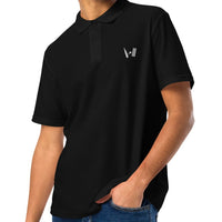 Side view of a man wearing a black polo shirt with distinctive white embroidery on the chest, paired with casual jeans for a sporty look.