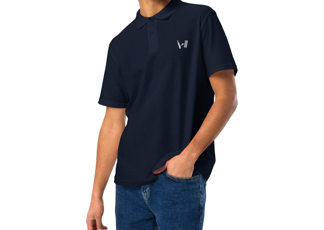 A young man wearing a navy blue polo shirt, casually styled with blue jeans, ideal for a relaxed look while enjoying sports events