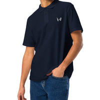 A young man wearing a navy blue polo shirt, casually styled with blue jeans, ideal for a relaxed look while enjoying sports events