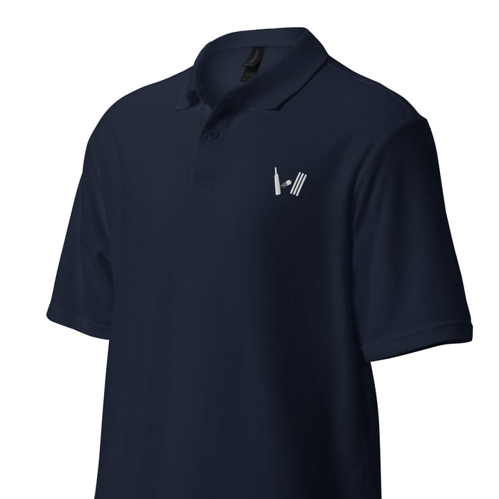 Front view of a navy blue polo shirt with a neat embroidery detail of a cricket bat and stumps on the left chest, laid flat for display.