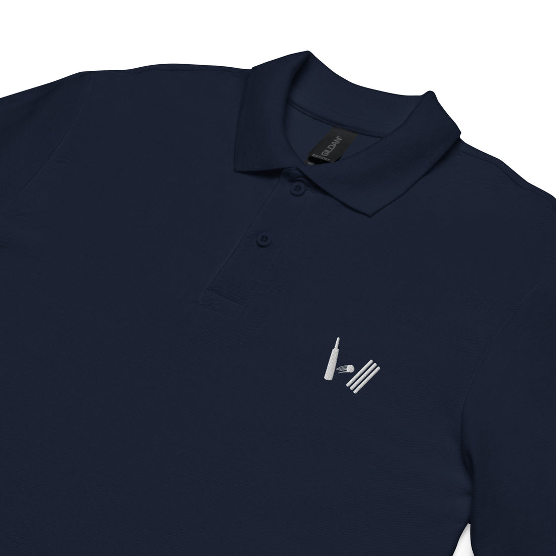 Close-up of a navy blue polo shirt showcasing detailed embroidery of a cricket bat and stumps on the left chest area