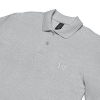 "Close-up view of a heather grey polo shirt showing detailed embroidery of a cricket bat and stumps on the left chest, laid flat.